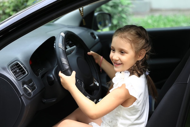 niña sentada al volante del coche de papá