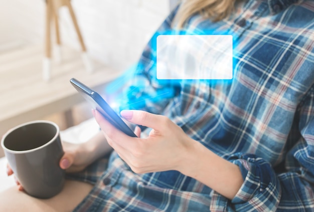 Foto la niña está sentada en la cama blanca. la mujer joven está buscando información en internet. ventana de mensaje vacía desde la pantalla del teléfono inteligente. redes sociales y nuevas ideas. concepto de comunicación. copiar el lugar del espacio