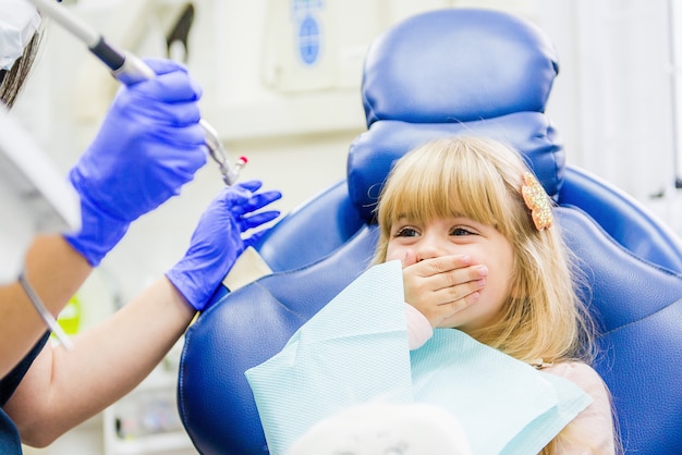 Niña sentada en el consultorio del dentista