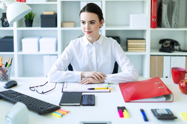 Foto una niña está sentada en el escritorio de la computadora en la oficina.