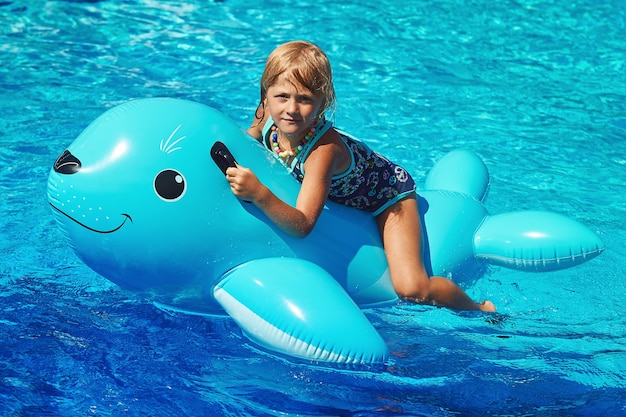 Niña sentada en el inflable Sea Lion en la piscina