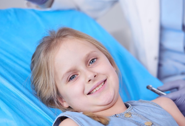 Niña sentada en la oficina de dentistas