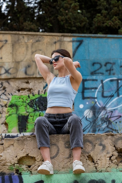 Niña sentada en la pared y estirando su oído