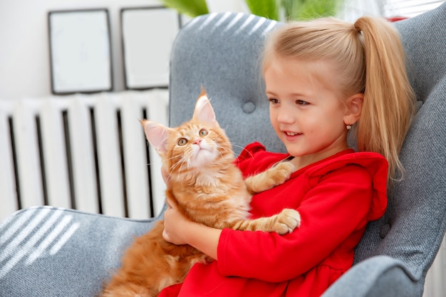 Niña sentada en una silla con un gato