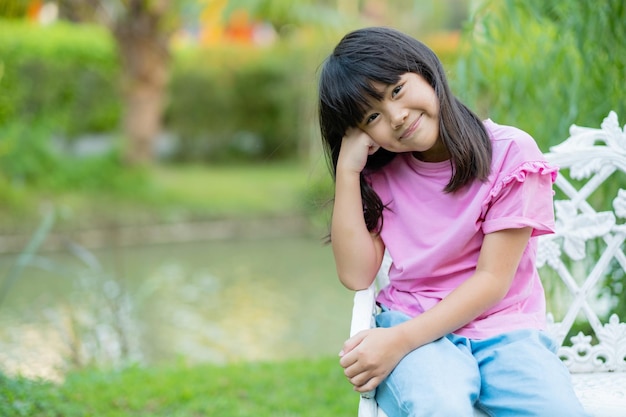 niña sentada en una silla en el jardín