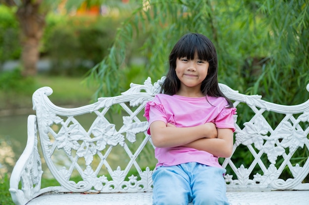 niña sentada en una silla en el jardín