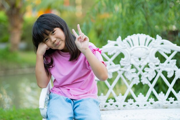 niña sentada en una silla en el jardín