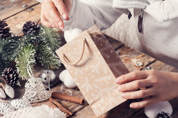 Niña sentada en su escritorio embalaje regalo de Navidad