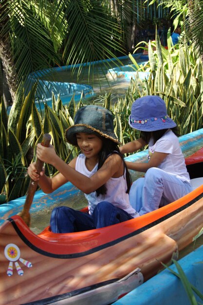 Foto niña sentada con su hermana en el barco