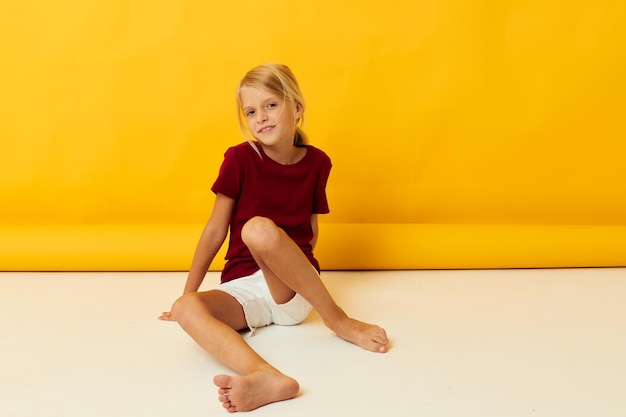 Niña sentada en el suelo emociones de fondo amarillo