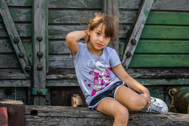 Foto niña sentada en un viejo tren de carga