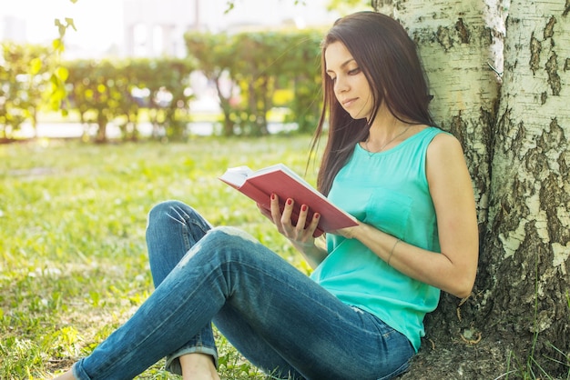 niña, sentado, en, pasto o césped, libro de lectura, en, verano