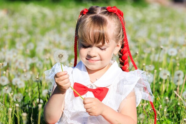 Una niña se sienta en la naturaleza en verano con un panda de juguete. foto de alta calidad