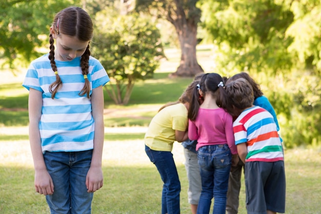 Foto niña sintiéndose dejada afuera en el parque