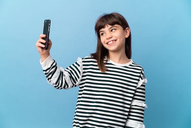 Niña sobre aislado haciendo un selfie