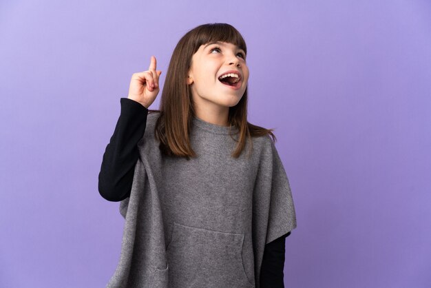 Niña sobre fondo aislado apuntando hacia arriba y sorprendido