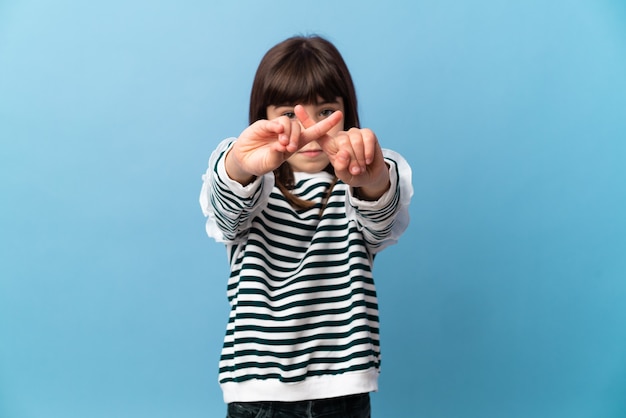 Niña sobre fondo aislado haciendo gesto de parada con la mano para detener un acto