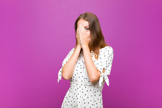 Niña sobre fondo morado sintiéndose asustada o avergonzada