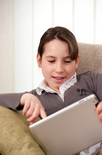 Niña en el sofá con tableta táctil