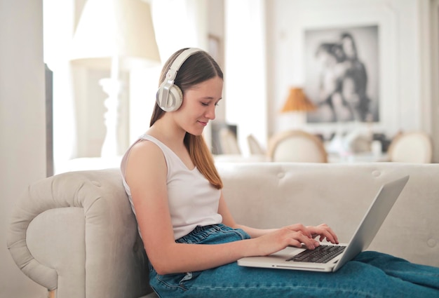 niña en un sofá usa una computadora