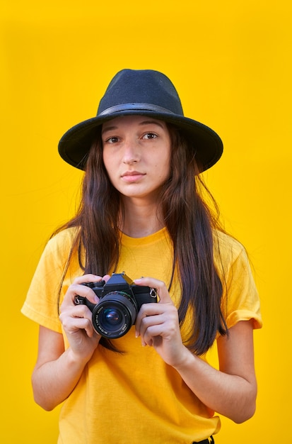 niña con sombrero y una cámara de fotos