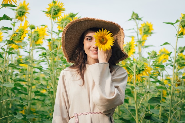 Niña con sombrero en un campo de girasoles