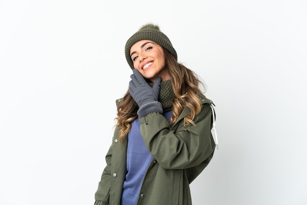 Foto niña con sombrero de invierno aislado en espacio en blanco feliz y sonriente