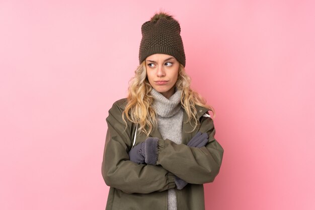 Niña con sombrero de invierno en rosa pensando en una idea