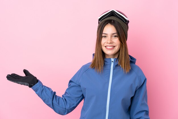 Niña con sombrero de invierno sobre pared rosa