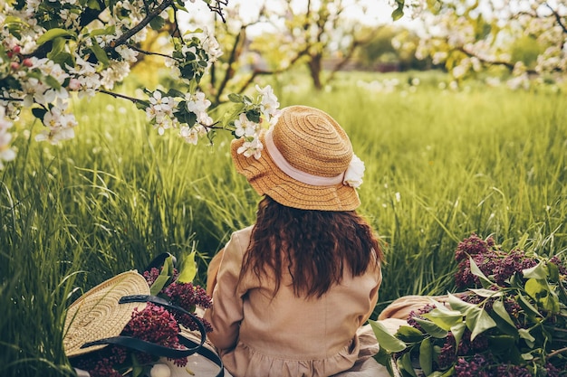 Niña con sombrero en el jardín en un picnic