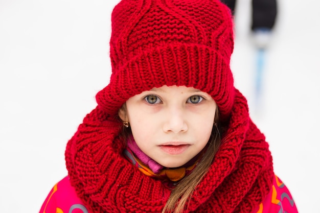 Niña con un sombrero de lana roja en Winter Park