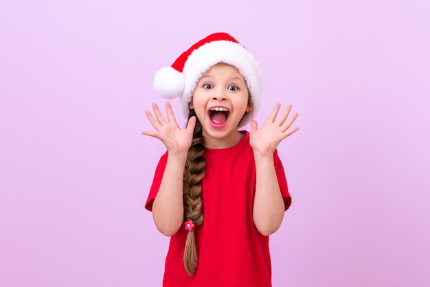 Una niña con un sombrero de Navidad y una larga coleta de pelo. muestra susto.