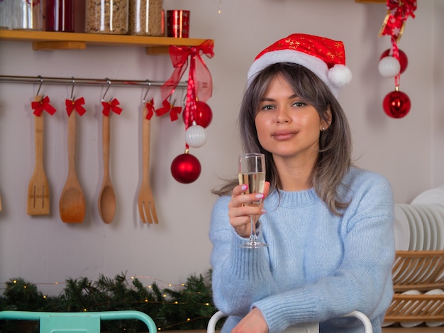 Una niña con un sombrero de Santa Claus está feliz por el año nuevo