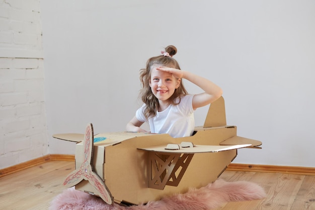 Niña soñadora jugando con un avión de cartón Infancia Fantasía imaginación