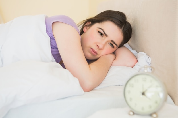 Niña soñolienta que se despierta en su cama