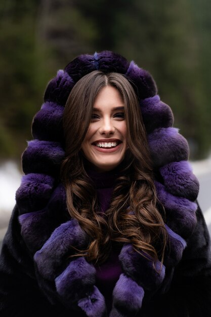 Niña sonriendo a la cámara en el bosque de invierno