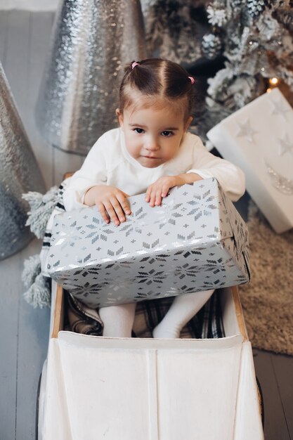 Niña sonriendo a la cámara rodeada de guirnaldas.