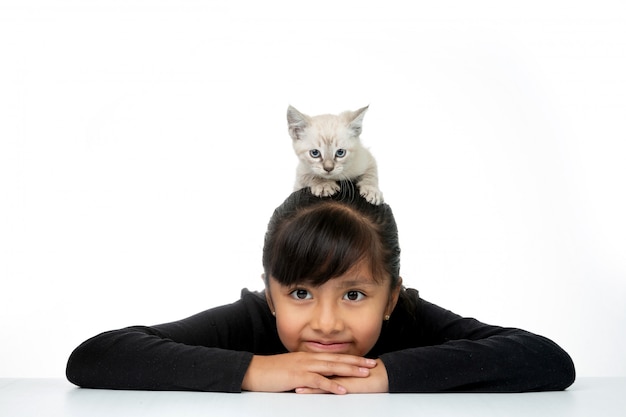 niña sonriendo con gatito blanco