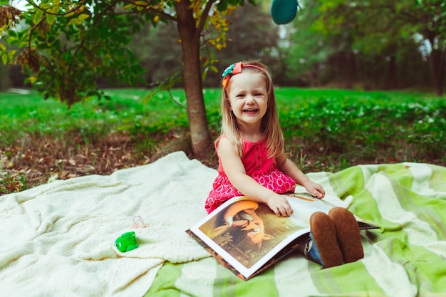 Foto niña sonriendo con un libro de dibujos