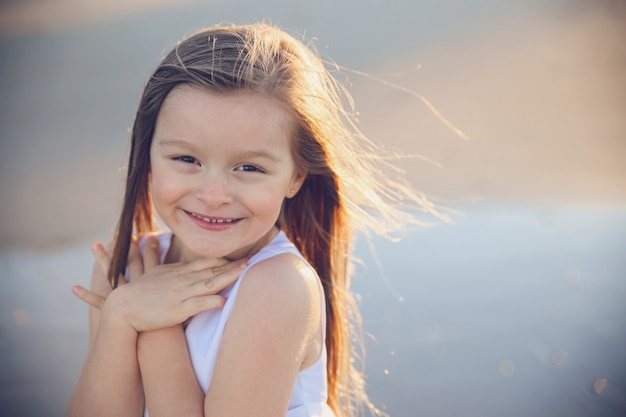 niña sonriendo y mostrando gesto de amor