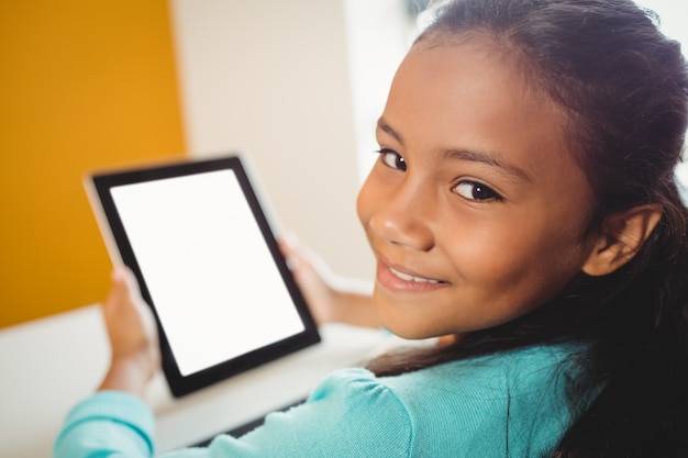 Niña sonriendo y usando una tableta