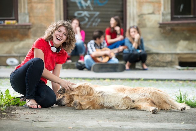 Niña sonriente acariciando a un perro