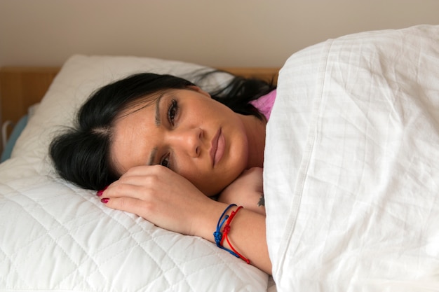 Niña sonriente acostada en la cama