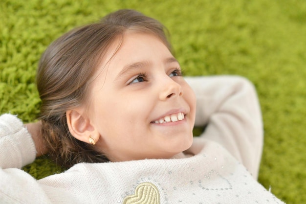 niña sonriente, acostado, en, el, alfombra