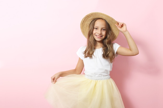 Niña sonriente alegre en ropa de moda sobre un fondo de color