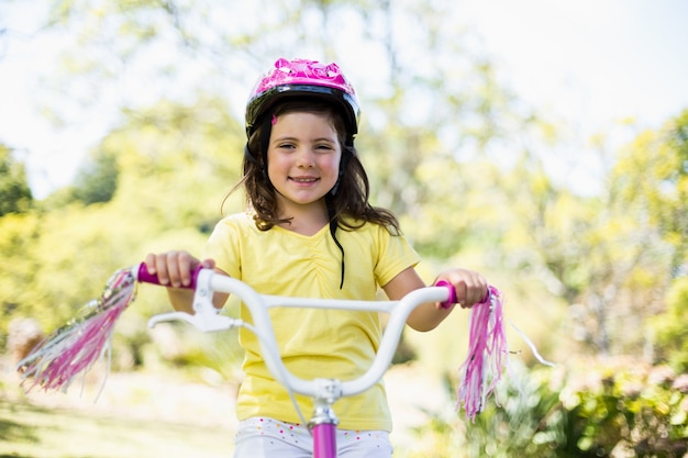 Niña sonriente andar en bicicleta