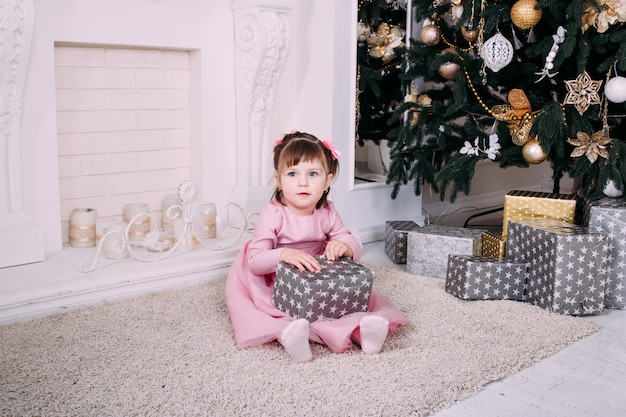 Niña sonriente con caja de regalo de navidad