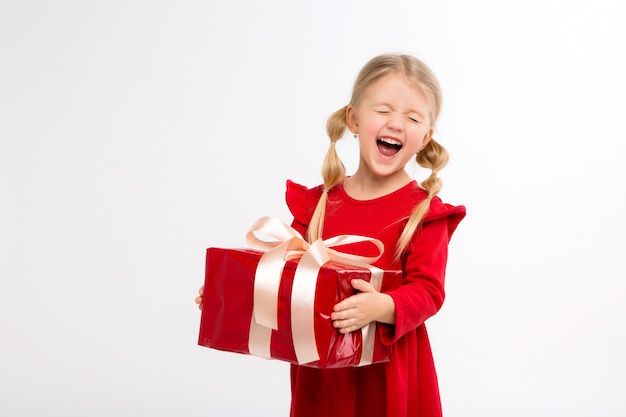 niña sonriente con caja de regalo roja en la mano