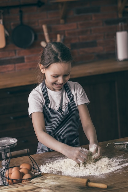 Niña sonriente cocinando con harina