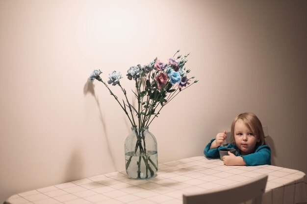 niña sonriente divertida comiendo y sentada en la mesa estilo de vida familiar